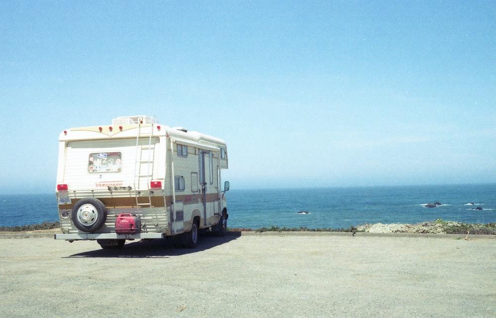 white and blue van on beach during daytime