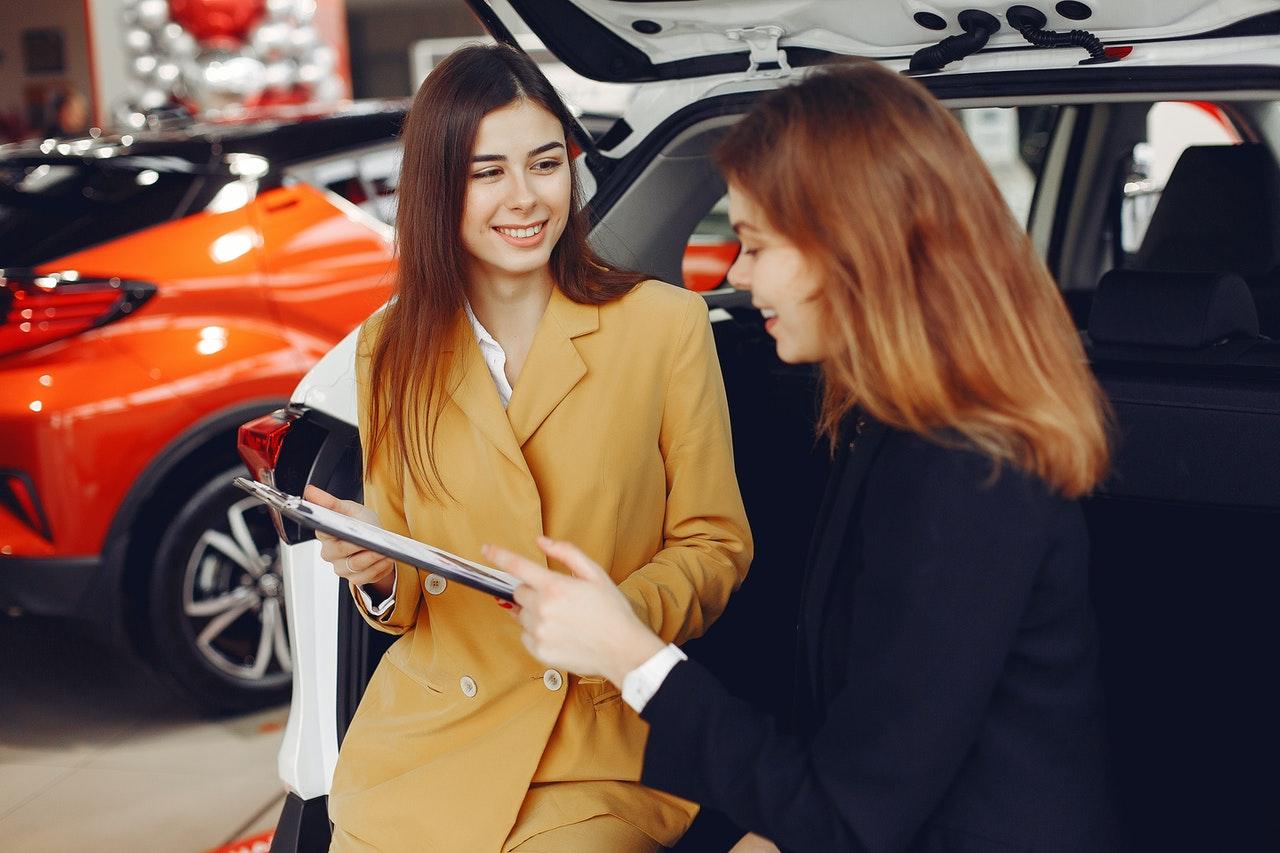 dealership personnel discussing the details of a car purchase with a customer